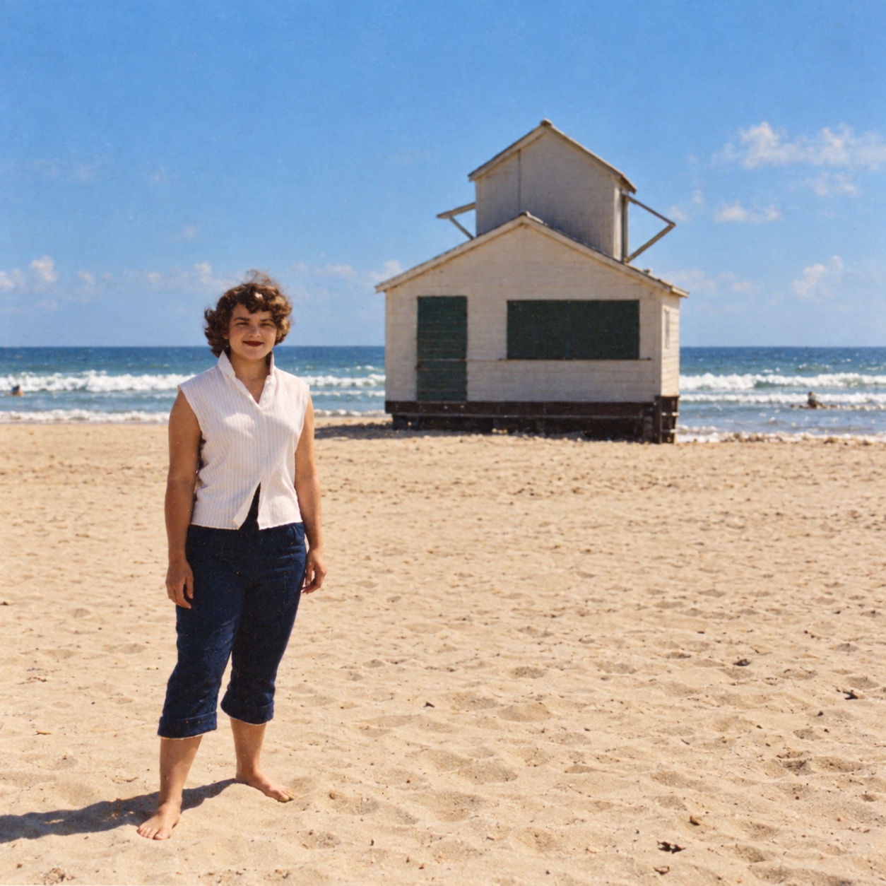 Judy standing on the beach near a lifeguard station.